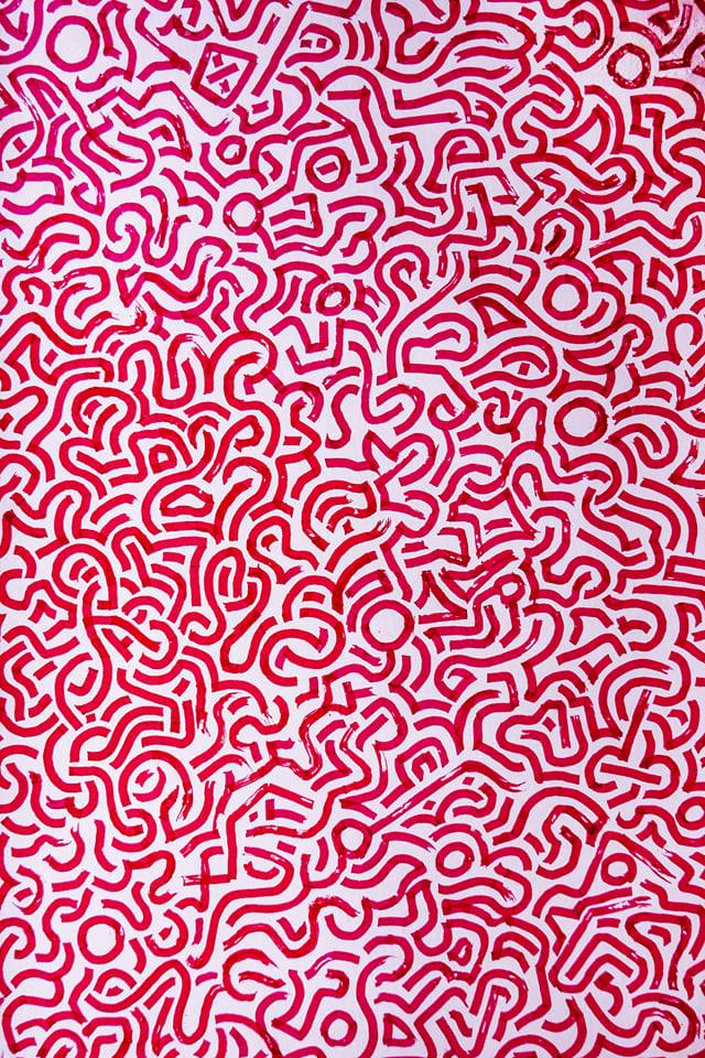 A dense all-over pattern of short, curved red strokes on white.